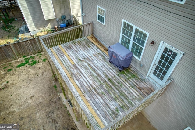 deck with a grill and fence