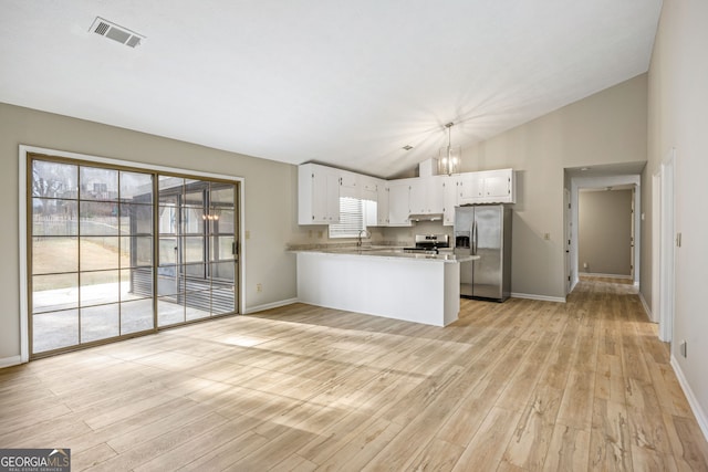 kitchen featuring visible vents, under cabinet range hood, a peninsula, stainless steel appliances, and a sink