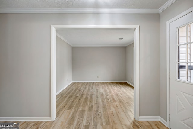 foyer featuring crown molding, wood finished floors, baseboards, and a textured ceiling