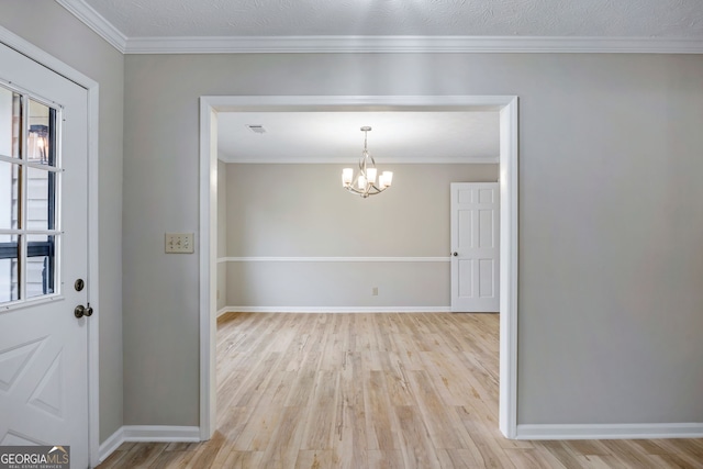 interior space featuring a chandelier, baseboards, light wood-style floors, and ornamental molding