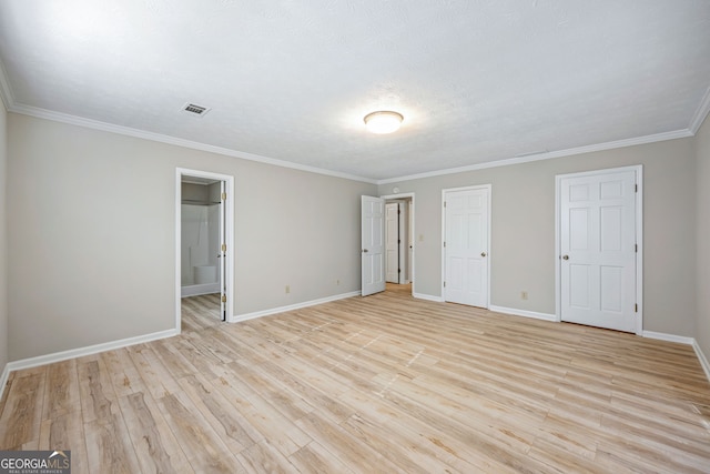 unfurnished bedroom with baseboards, visible vents, ensuite bath, ornamental molding, and light wood-type flooring