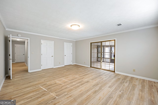 empty room featuring light wood-type flooring, baseboards, and crown molding