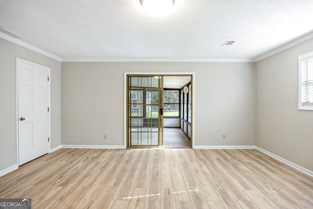 unfurnished room with light wood-type flooring, baseboards, a textured ceiling, and visible vents