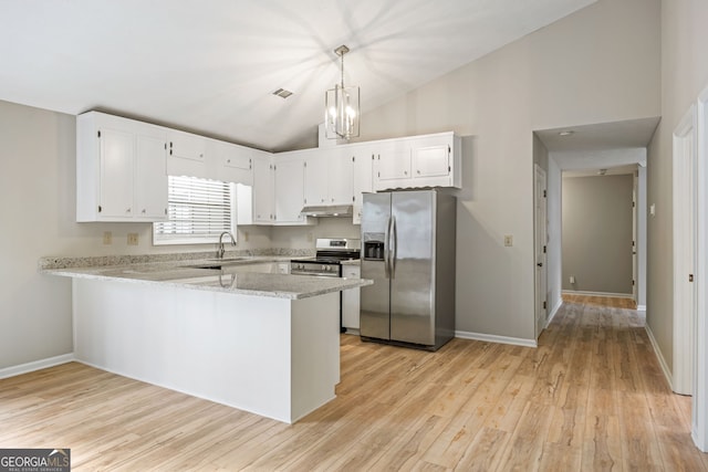 kitchen featuring under cabinet range hood, vaulted ceiling, a peninsula, white cabinets, and stainless steel appliances