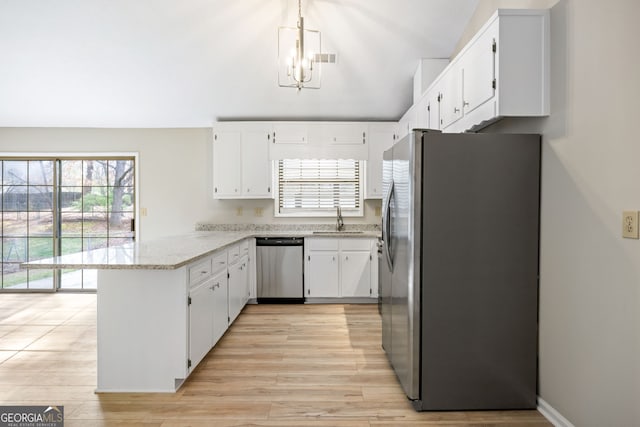 kitchen featuring a peninsula, stainless steel appliances, light wood-style floors, white cabinetry, and a sink