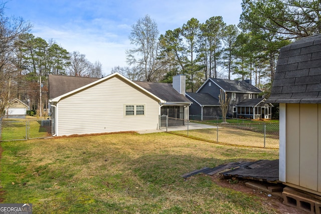 back of property featuring fence, a yard, a sunroom, a patio area, and a gate