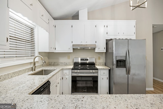 kitchen with under cabinet range hood, a sink, stainless steel appliances, light stone countertops, and vaulted ceiling