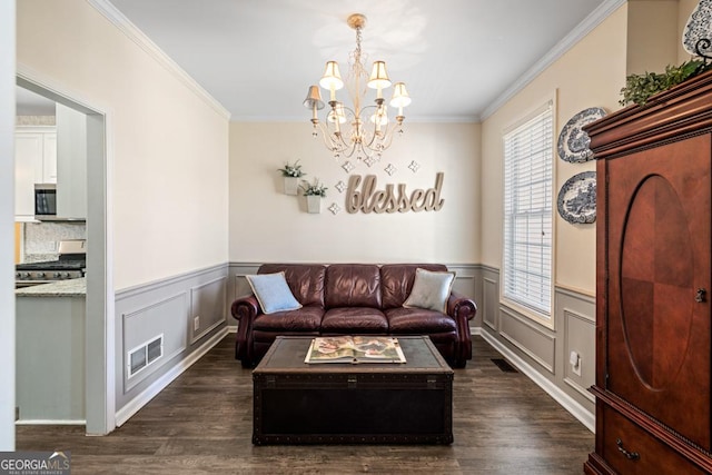 living area with dark wood-style flooring, a chandelier, visible vents, and ornamental molding