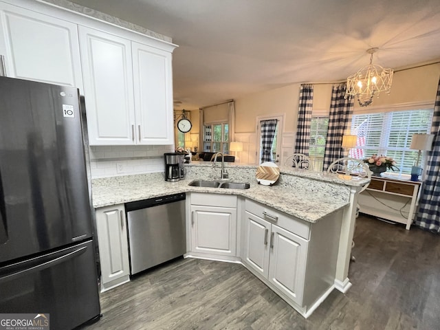 49 Inverness Ct, Hiram, GA 30141 - kitchen with freestanding refrigerator, stainless steel dishwasher, a sink, a peninsula, and dark wood-style flooring