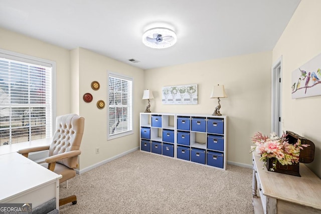 carpeted office space with baseboards, plenty of natural light, and visible vents