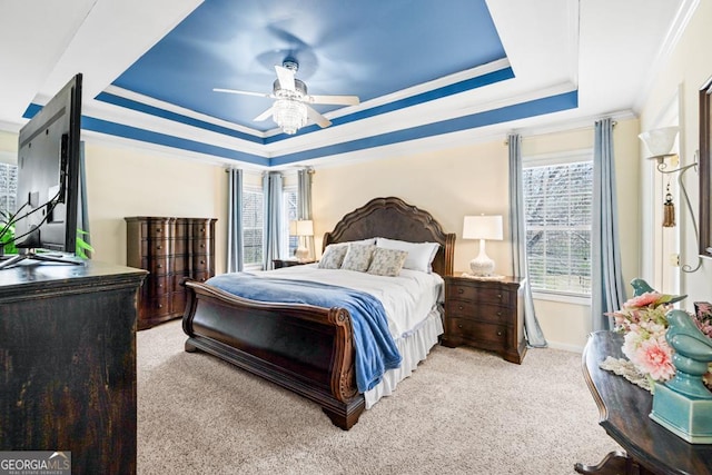 bedroom with crown molding, a raised ceiling, carpet floors, and multiple windows