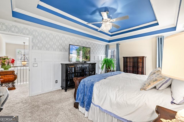 bedroom with crown molding, carpet, a raised ceiling, and a decorative wall