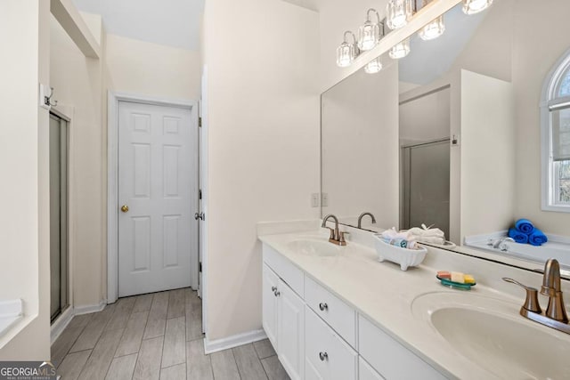 full bath featuring a sink, a shower stall, and double vanity