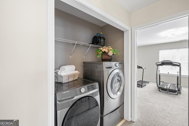 laundry room featuring baseboards, laundry area, washer and clothes dryer, and carpet