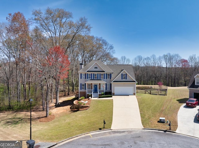 traditional-style house with fence, a chimney, concrete driveway, and a front yard
