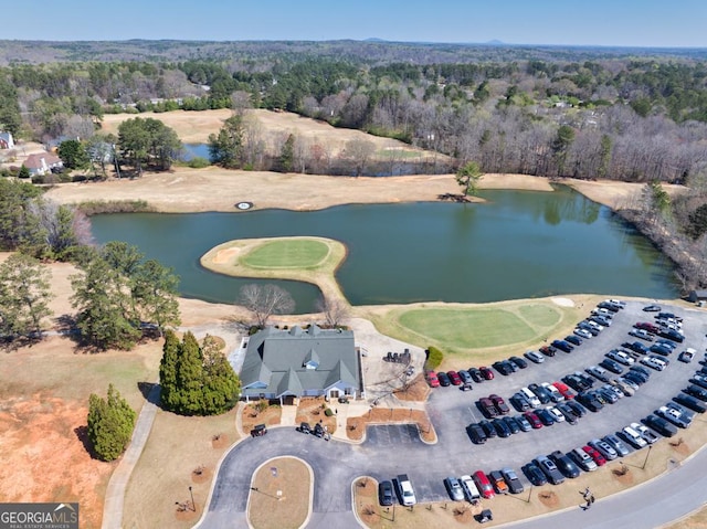 bird's eye view with a view of trees, view of golf course, and a water view