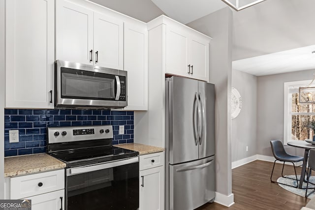 kitchen featuring backsplash, dark wood-type flooring, baseboards, appliances with stainless steel finishes, and white cabinets