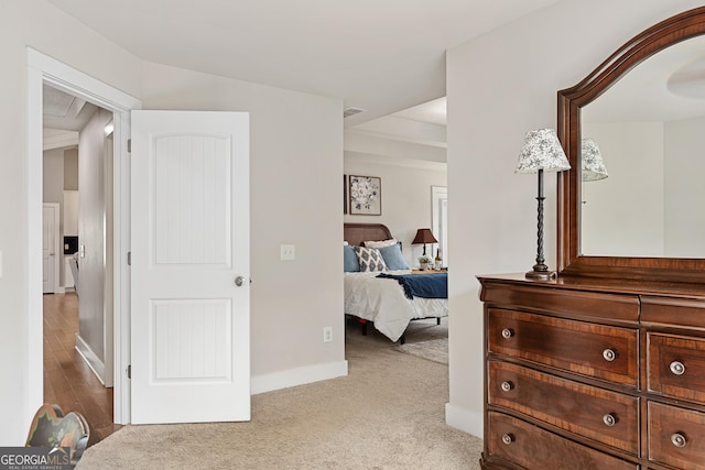 bedroom with light colored carpet and baseboards