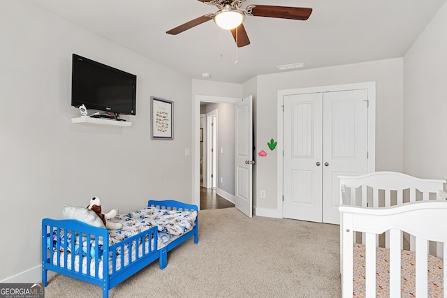 carpeted bedroom featuring baseboards, visible vents, a closet, and ceiling fan