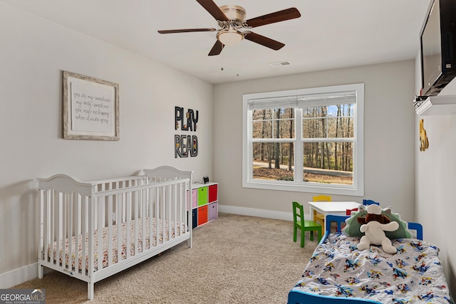 carpeted bedroom with visible vents, baseboards, and a ceiling fan