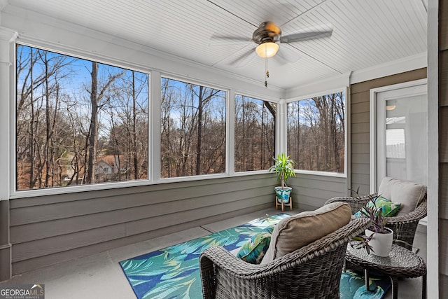 unfurnished sunroom with plenty of natural light and a ceiling fan