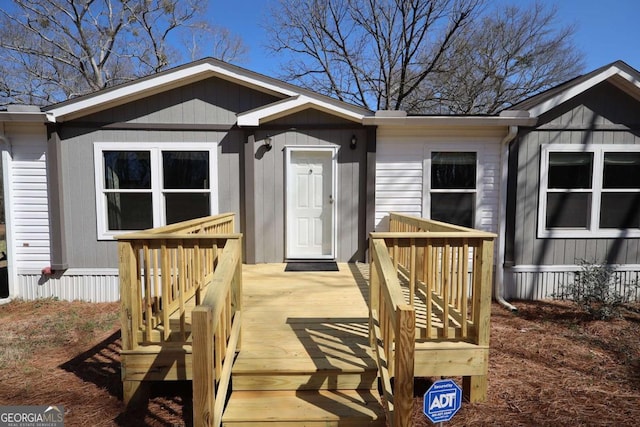 view of exterior entry featuring a wooden deck