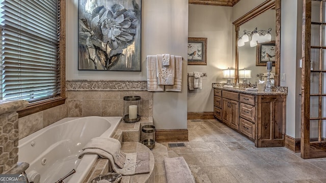 full bath featuring a tub with jets, visible vents, vanity, and baseboards