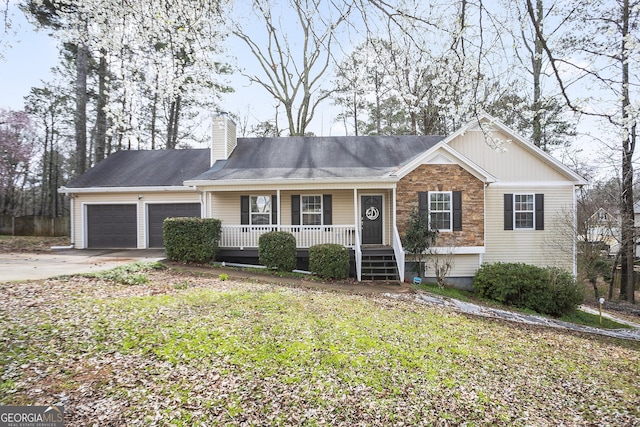 ranch-style house with driveway, stone siding, covered porch, a garage, and a chimney