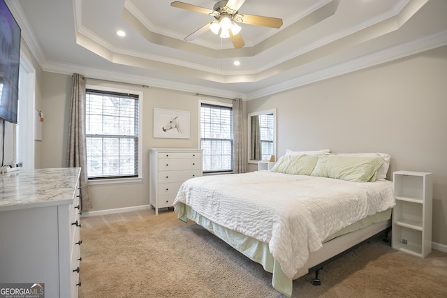 bedroom with light carpet, a ceiling fan, a tray ceiling, crown molding, and baseboards