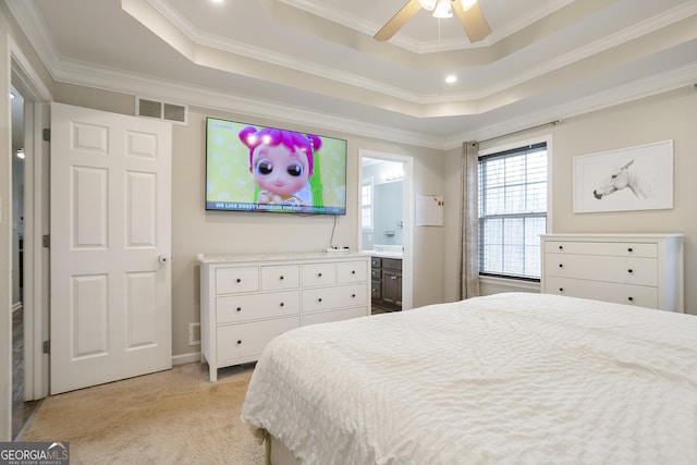 bedroom featuring visible vents, connected bathroom, crown molding, a tray ceiling, and light carpet