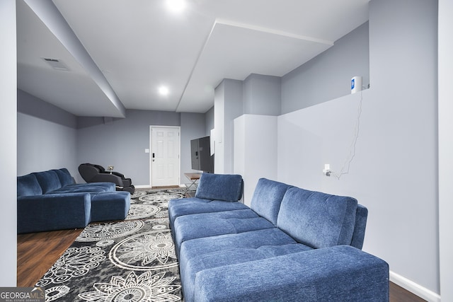 living room featuring dark wood-style floors, visible vents, and baseboards