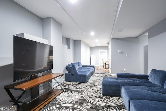 living room with wood finished floors, visible vents, and baseboards