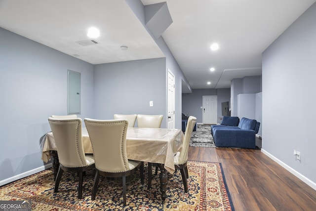 dining room featuring electric panel, visible vents, baseboards, and dark wood-style floors