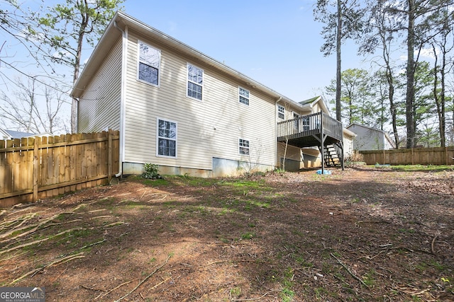 back of house with stairway, a deck, and fence