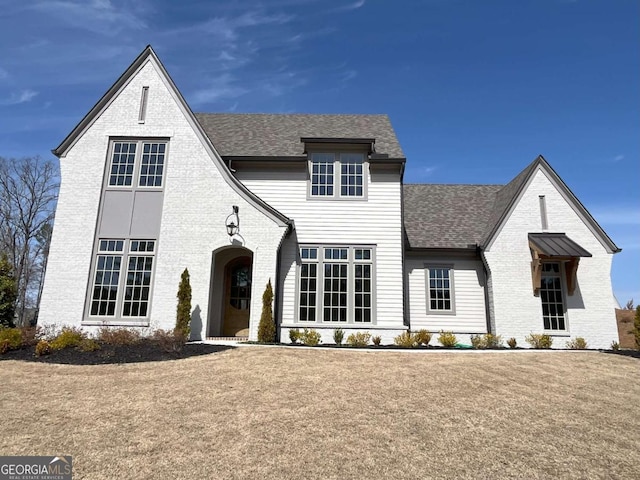 view of front of house featuring brick siding and a shingled roof