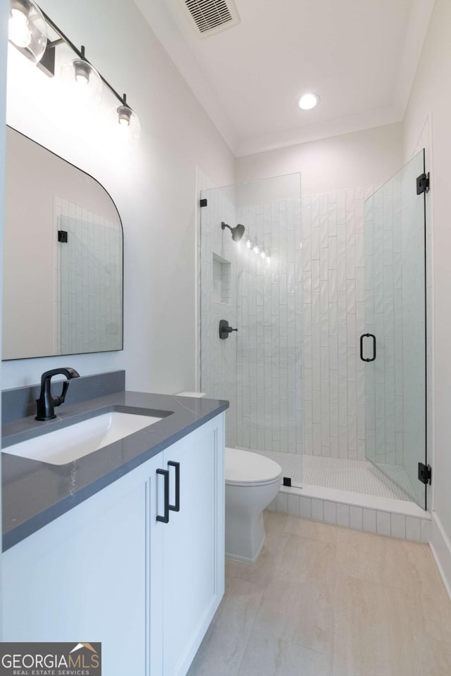 bathroom featuring vanity, visible vents, ornamental molding, a shower stall, and toilet