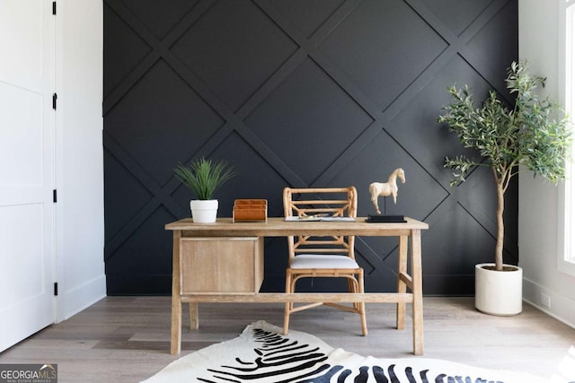 office space featuring a decorative wall and wood finished floors