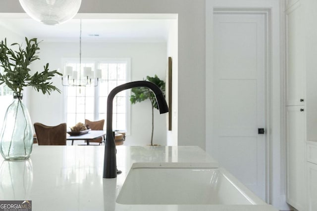 interior details with a chandelier, hanging light fixtures, and a sink