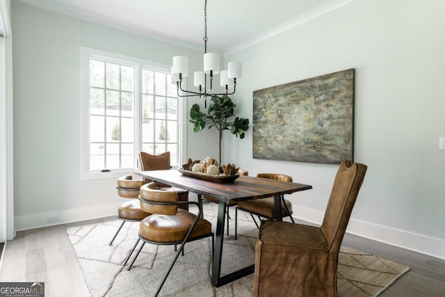 dining area with an inviting chandelier, wood finished floors, baseboards, and ornamental molding