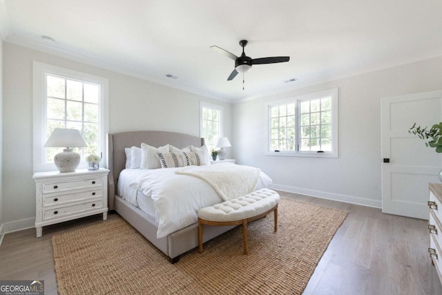 bedroom with baseboards, light wood-style flooring, and ornamental molding