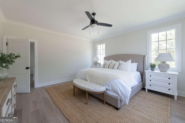 bedroom with light wood-style flooring, crown molding, and baseboards