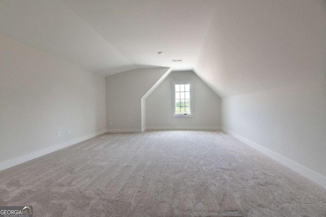 bonus room with visible vents, light colored carpet, baseboards, and lofted ceiling