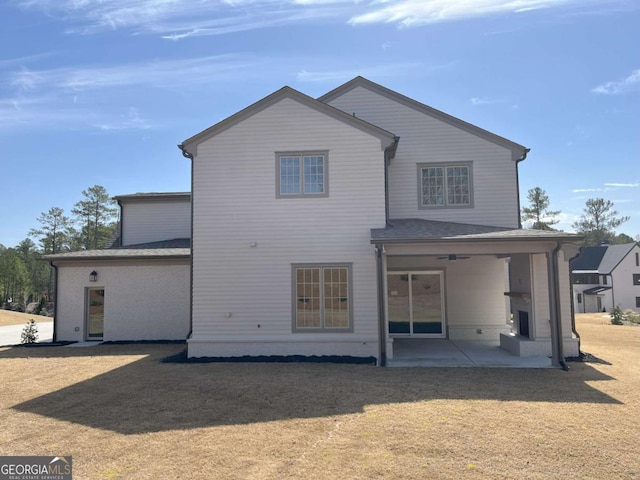 back of house featuring a patio and a lawn