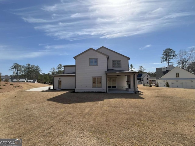 back of house featuring a patio and a yard