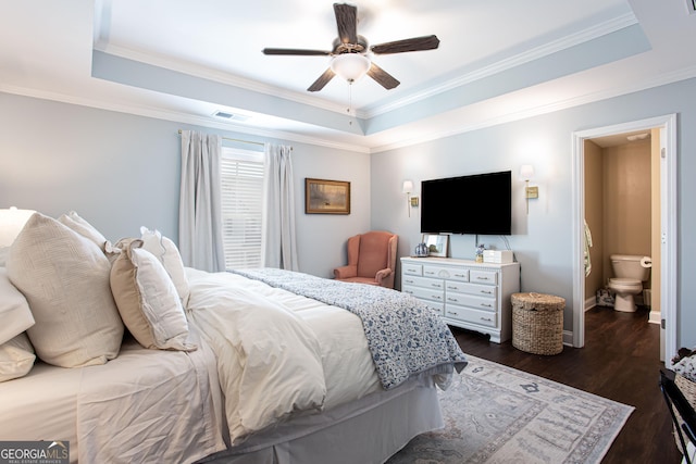 bedroom with a tray ceiling, ornamental molding, visible vents, and dark wood-type flooring