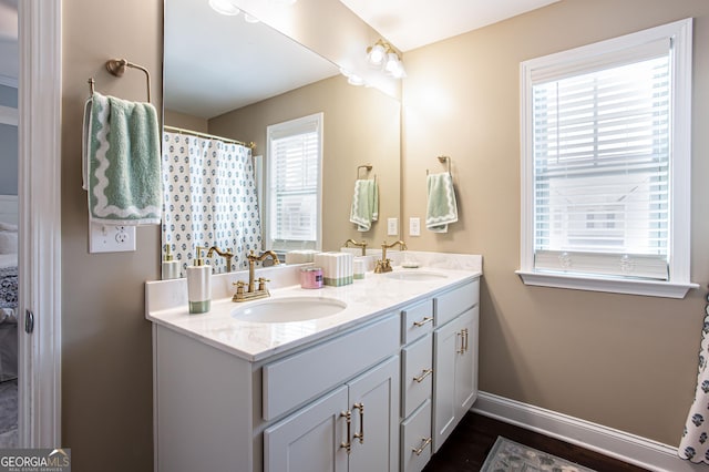 full bathroom with plenty of natural light, baseboards, and a sink