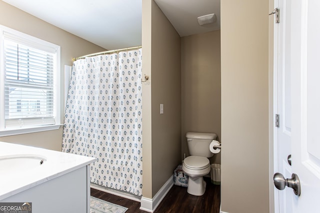 full bathroom featuring curtained shower, baseboards, toilet, wood finished floors, and vanity