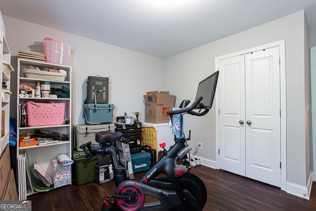 exercise room with wood finished floors and baseboards