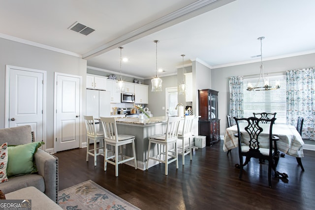 kitchen featuring a kitchen bar, a wealth of natural light, visible vents, and appliances with stainless steel finishes