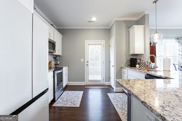 kitchen with a sink, light stone countertops, appliances with stainless steel finishes, and white cabinetry